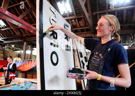 Lavoratori in loco presso la Glanusk Estate di Crickhowell, preparando il sito in preparazione per il Green Man Festival 2021. . Il laboratorio di pittura di cartello in Foto Stock