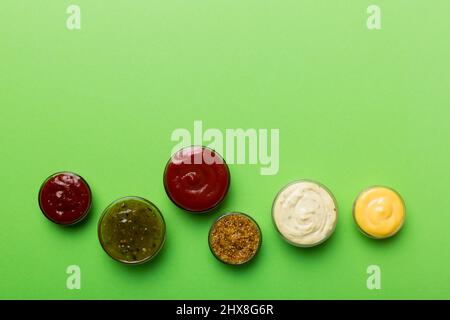 Diversi tipi di salse in ciotole su un pannello colorato . Vista dall'alto, vari salse copia spazio. Foto Stock