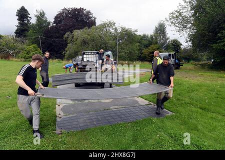 Lavoratori in loco presso la Glanusk Estate di Crickhowell, preparando il sito in preparazione per il Green Man Festival 2021. Lavoratori che pongono i molti centr Foto Stock