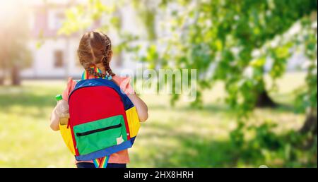 Ragazza che va a studiare nella scuola primaria Foto Stock