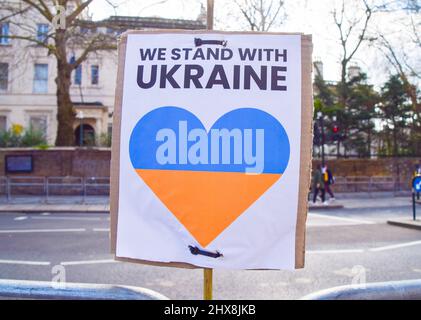 Londra, Regno Unito. 10th marzo 2022. "Siamo in piedi con l'Ucraina" segno di cuore di fronte all'ambasciata russa. I manifestanti continuano ad aggiungere segni e messaggi anti-Putin, anti-guerra e pro-Ucraina di fronte all’ambasciata mentre l’attacco russo all’Ucraina si intensifica. Si sono sempre più richieste di cambiare il nome della strada di Kensington, dove si trova l'ambasciata, in Zelensky Avenue. Foto Stock