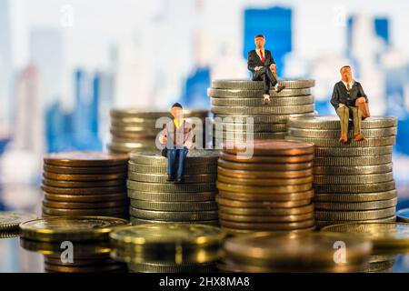 Persone in miniatura: Piccoli uomini d'affari seduti su pile di monete, concetto di denaro, finanza, crescita aziendale. Foto Stock