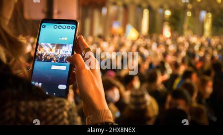 Tbilisi, Georgia - 1st marzo, 2022: Tipo di persona sul touch screen sullo smartphone per inviare notizie feed aggiornamento in protesta. L'esercito russo entrò in Ukrai Foto Stock