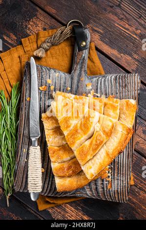 Torta di spanakopita greca fatta in casa con formaggio biologico su tavola di legno. Sfondo in legno. Vista dall'alto Foto Stock