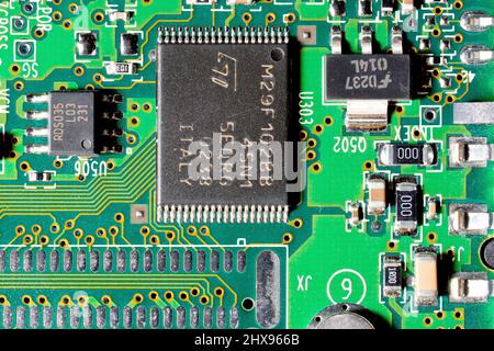 Primo piano di un circuito stampato di un computer, che mostra varie dimensioni di chip integrati e altri componenti elettronici. Foto Stock