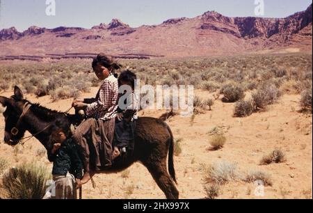 Un ragazzo e una ragazza Navajo su un burro ca. 1954-1959 Foto Stock