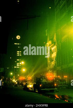 I camion dei vigili del fuoco e i soccorritori aiutano a spegnere un incendio a New York City ca. 1965 Foto Stock