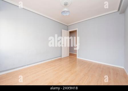 Soggiorno vuoto con pavimenti in legno duro, pareti dipinte di grigio, soffitto in gesso e legno bianco Foto Stock