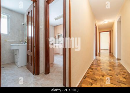 Distributore di un appartamento residenziale con accesso ad un bagno, una cucina e un lungo corridoio che conduce ad altre stanze Foto Stock