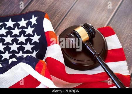 Gavel del giudice e bandiera americana su tavola di legno. Foto Stock