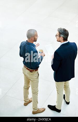 Esecuzione di alcune idee oltre il boss. Colpo ad angolo di due uomini d'affari che parlano in ufficio. Foto Stock