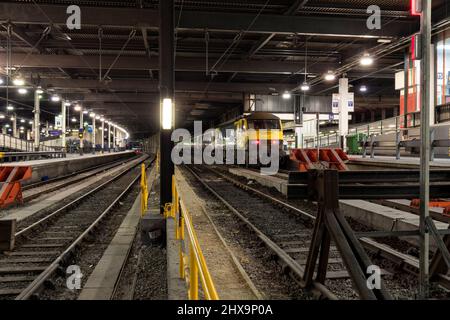 Freightliner classe 90 locomotiva elettrica 90042 presso la stazione di Londra Euston con il magazzino vuoto del treno notturno caledonian Sleeper Train Foto Stock