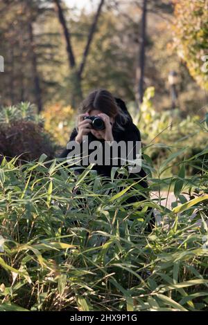 Fotografo di fauna selvatica mimetizzazione. Una donna si nasconde mentre si scattano foto in natura. Persona irriconoscibile. Foto Stock