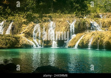 Turista godendo le piscine belle di Semuc Champey, Rio Cabohon, Lanquin, alta Verapaz, Guatemala Foto Stock