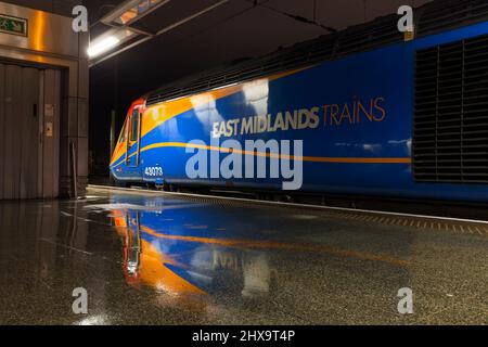 Un treno ad alta velocità delle East Midlands Trains Intercity 125 a London St Pancras che mostra il logo riflesso nella piattaforma umida Foto Stock