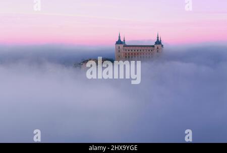 Antico castello avvolto nella nebbia in coloratissimo color porpora alba Foto Stock