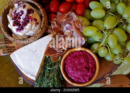 Formaggio, prosciutto di Parma, salsa, frutta e fette di pane marrone sul tavolo Foto Stock