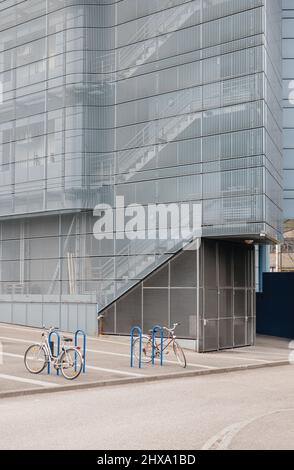 Edificio con corpo in acciaio e scale multiple con bici parcheggiata davanti Foto Stock