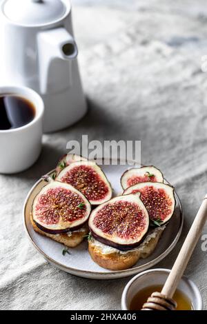 Due sandwich con fichi, timo su sfondo testurizzato. Composizione della colazione Foto Stock