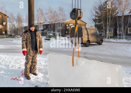 Lavoratore in una giacca con un cappuccio e una maglia di lana hat sul posto di lavoro Foto Stock