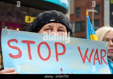 Un vecchio dimostratore ha un segno per fermare la guerra durante una protesta contro l'invasione russa dell'Ucraina a Times Square a New York City il 5 marzo 2022. Foto Stock