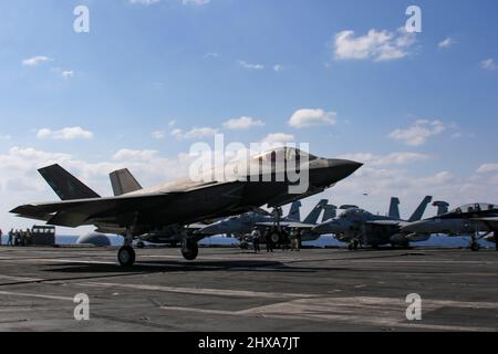 PHILIPPINE SEA (10 marzo 2022) un F-35C Lightning II, assegnato ai 'Cavalieri neri' di Marine Fighter Attack Squadron (VMFA) 314, si prepara a fare un atterraggio arrestato sul ponte di volo del vettore aereo di classe Nimitz USS Abraham Lincoln (CVN 72). Abraham Lincoln Strike Group è in fase di implementazione pianificata nell'area delle operazioni della flotta USA 7th per migliorare l'interoperabilità attraverso alleanze e partnership, fungendo da forza di risposta pronta a supportare una regione indopacifica libera e aperta. (STATI UNITI Foto Navy di Sint. Di comunicazione di massa Seaman Aprentice Julia Brockman) Foto Stock