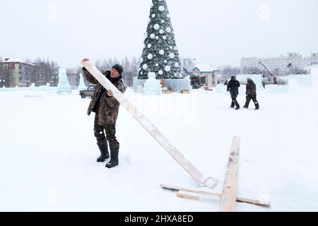 Costruttore con un bordo nelle sue mani sullo sfondo dell'albero di Natale Foto Stock