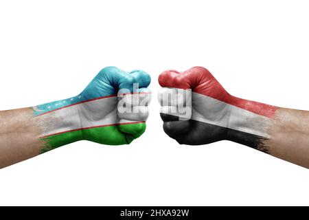 Due mani si pugno l'una all'altra su sfondo bianco. Bandiere di paese dipinte pugni, conflitto concetto di crisi tra uzbekistan e yemen Foto Stock