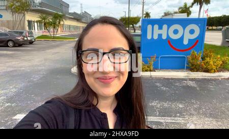 Happy girl prende un selfie a IHOP Miami - MIAMI, STATI UNITI - 20 FEBBRAIO 2022 Foto Stock