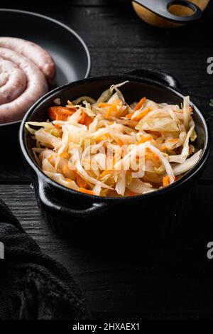 Set conservante sauerkraut, su sfondo di tavola di legno nero Foto Stock