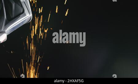 Forge workshop. Fucina di produzione manuale. Chiudere i dettagli di scintille, operaio industriale utilizzando smerigliatrice angolare e il taglio di acciaio. Il fabbro rende ir Foto Stock
