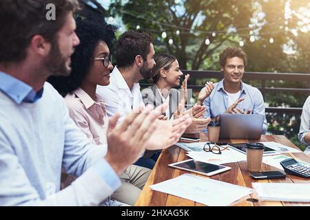 Ogni successo è da celebrare. Foto di un gruppo di colleghi che hanno applaudato durante una riunione in un bar. Foto Stock