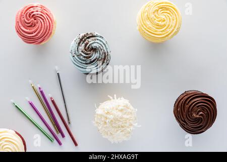 Vista dall'alto dei cupcake con glassa e spolverini, pronti per le candele. Foto Stock