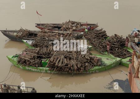 Barche caricate con legna da ardere per cerimonie di cremazione sul fiume Gange, Marnikarnika Ghat, Varanasi, Uttar Pradesh, India. Foto Stock