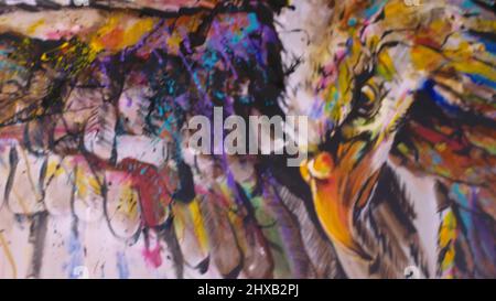 Il designer d'artista disegna un'aquila sul muro. Decoratore artigiano dipinge un quadro con colore olio acrilico. Primo piano, aspetto cinematografico con magia scura. Pittore p Foto Stock