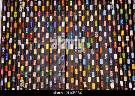 Jimena de la Frontera, Spagna - 9 Marzo, 2022: Colorata tenda a mosca originale fatta di catena e tappetti di vino dipinti davanti ad una porta marrone scuro Foto Stock