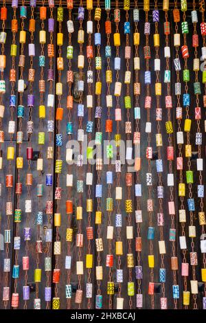 Jimena de la Frontera, Spagna - 9 Marzo, 2022: Colorata tenda a mosca originale fatta di catena e tappetti di vino dipinti davanti ad una porta marrone scuro Foto Stock