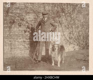 Foto d'epoca di un ragazzo vestito in modo intelligente, bastone da passeggio, cane da compagnia, Edwardian Inghilterra 1900s Foto Stock