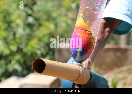 Bottiglia di plastica con molte polveri colorate attaccate ad alcuni gadget che soffia fuori la polvere colore, Holi gadget per gulal lancio Foto Stock