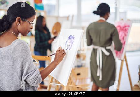 Un'altra sessione d'arte. Foto sfocata di un gruppo di persone che dipinge in uno studio d'arte. Foto Stock