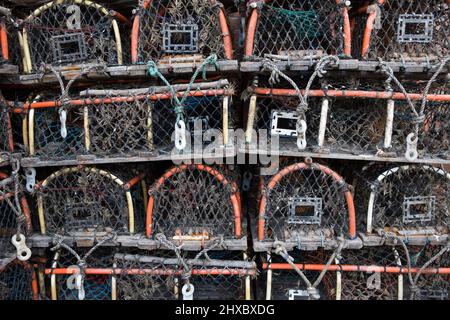 Vasi di aragosta impilati in file sul lato della banchina. Pesca di granchio sfondo Foto Stock