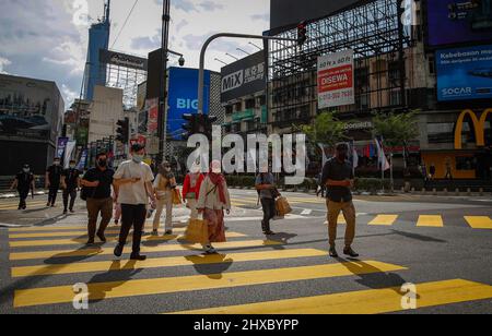 Kuala Lumpur, Malesia. 10th Mar 2022. I pedoni indossano le maschere per il viso come precauzione contro la diffusione di convivid-19 visto attraversare la strada vicino al quartiere dello shopping. (Foto di Wong Fok Loy/SOPA Images/Sipa USA) Credit: Sipa USA/Alamy Live News Foto Stock