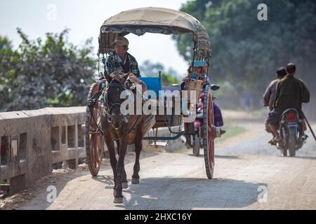 Mandalay, Myanmar - 11 gennaio 2016: Un uomo non identificato che guida una carrozza trainata da cavalli alla periferia di Mandalay, Myanmar. Foto Stock