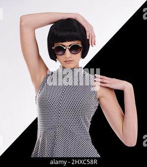 Gli unici due colori di cui hai bisogno nella moda. Studio girato di una giovane donna retrò-elegante su sfondo bianco e nero. Foto Stock
