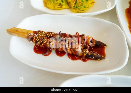 Nella vecchia campagna, piccoli polpi sono stati arrotolati in paglia e cotti al forno, ma oggi si arrotolano e cuociono invece spiedini di legno. Foto Stock