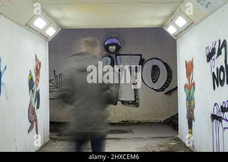 uomo che cammina attraverso il tunnel sottopasso sotto strada durante la notte leeds regno unito Foto Stock