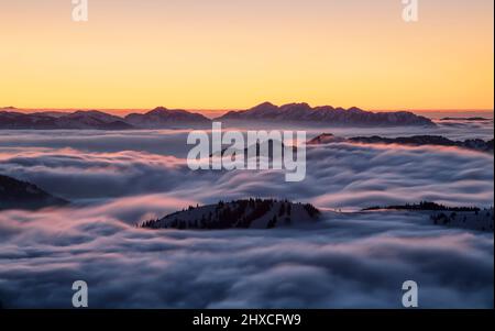 Montagne innevate dopo il tramonto sul mare di nebbia. Hörnergruppe e Nagelfluhkette, Alpi di Allgäu. Baviera, Germania, Europa Foto Stock