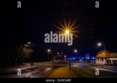 Strada deserta di notte con una rotonda nella piccola città di Luckenwalde Foto Stock