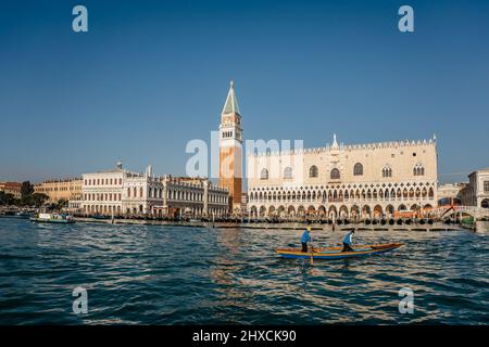 Venezia,Italia-Gennaio 29,2022. Famosa Piazza San Marco con Palazzo dei Dogi, campanile in giornata di sole, gente che paddling in barca. Mattina presto in popolare Foto Stock