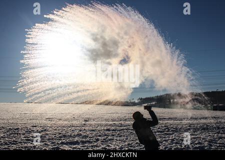 Effetto Mpemba, l'acqua bollente viene gettata nell'aria a temperature inferiori allo zero Foto Stock